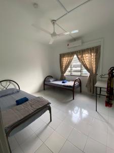 um quarto com 2 camas e uma janela em YAYA HOMESTAY CYBERJAYA & PUTRAJAYA em Cyberjaya