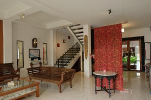 sala de estar con sofá, mesa y escalera en Mawar Asri Hotel, en Yogyakarta