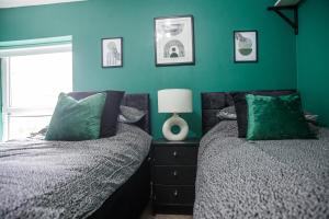 een slaapkamer met 2 bedden en een groene muur bij SEAVIEW - BTSPORTS - Contractors in Cleethorpes