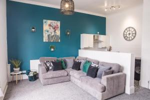 een woonkamer met een bank en een blauwe muur bij SEAVIEW - BTSPORTS - Contractors in Cleethorpes