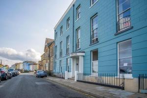 un edificio azul al lado de una calle en No 6 Croft House - 1 Bedroom Apartment - Tenby, en Tenby