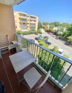 a balcony with a table and chairs and a view of a parking lot at Studio apartment Fréjus in Fréjus