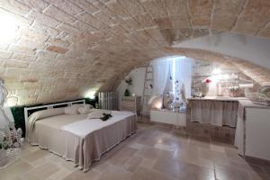 a bedroom with a bed and a stone wall at La Vitagira in Monopoli