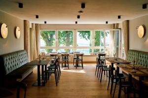 un ristorante con tavoli e sedie e una grande finestra di Hofgut Wißberg - Das Weinberghotel a Sankt Johann