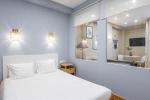 a bedroom with a white bed and a mirror at Kolonaki Suites by Olala Homes in Athens +24 photos