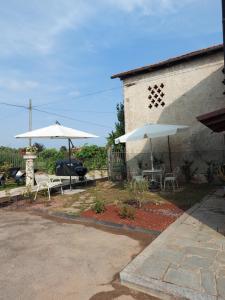 a patio with two umbrellas and a table and chairs at LA CA' 'D PINET in Cuneo