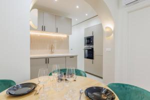 een keuken met een houten tafel met wijnglazen erop bij Modern Apartment near MontmartreSacré Cœur in Parijs