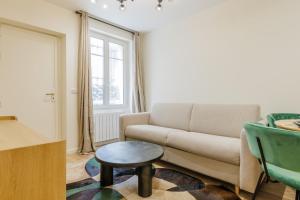 - un salon avec un canapé et un tabouret dans l'établissement Modern Apartment near MontmartreSacré Cœur, à Paris
