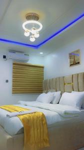 two large beds in a room with a ceiling at Thistle Greens Apartment in Ikeja