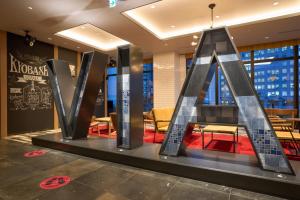 a sculpture of the letter m in a lobby at Via Inn Prime Osaka Kyobashi in Osaka +48 photos