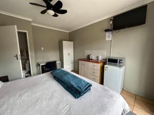a bedroom with a bed and a ceiling fan at Cornerstone Guest House in Polokwane