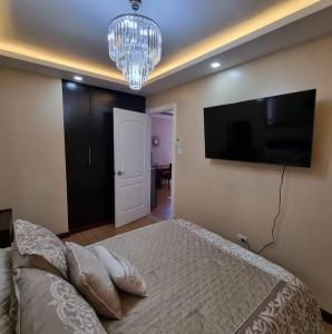 - une chambre avec un lit et une télévision à écran plat dans l'établissement A beautiful two-bedroom Mansionette at Appleone Banawa, à Cebu