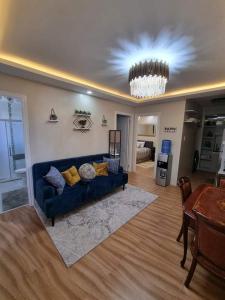 - un salon avec un canapé bleu et une table dans l'établissement A beautiful two-bedroom Mansionette at Appleone Banawa, à Cebu