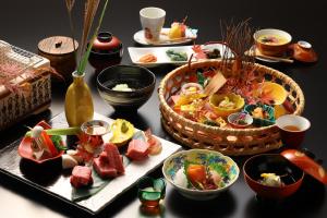 einen Tisch mit Teller mit Lebensmitteln und Körben in der Unterkunft Hotel Tamanoyu in Matsumoto