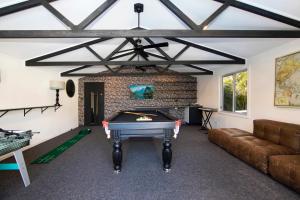 a living room with a pool table in front of a fireplace at Woy Woy Staycation - Luxury Pool & Spa & Games Vacation in Woy Woy