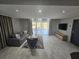a living room with a couch and a tv at Casa De Luxe in Ballito