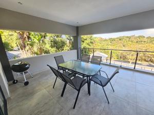 a dining room with a table and chairs on a balcony at Casa De Luxe in Ballito