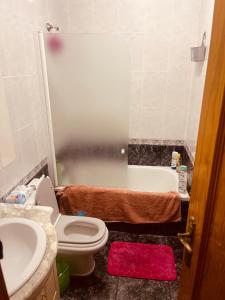 a bathroom with a toilet and a sink and a tub at Аппартаменты Эль Эхидо in El Ejido