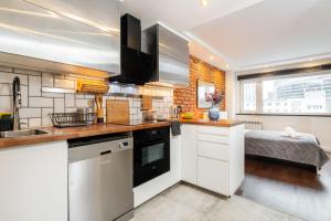 een keuken met witte kasten en een spoelbak bij Chmielna 106B Centrum by VAYA STAYS in Warschau