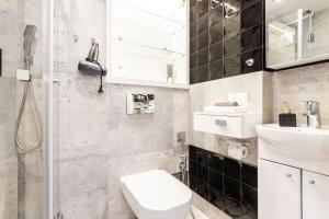 een badkamer met een toilet, een wastafel en een douche bij Chmielna 106B Centrum by VAYA STAYS in Warschau +8 foto's