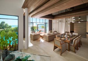 a dining room and living room with a table and chairs at PARKROYAL Langkawi Resort in Pantai Cenang