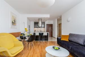 a living room with a couch and a table at Modern Apartment with FREE parking spot in Kraków