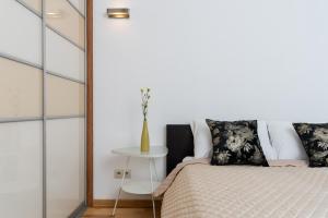 a bedroom with a bed and a table at Modern Apartment with FREE parking spot in Kraków