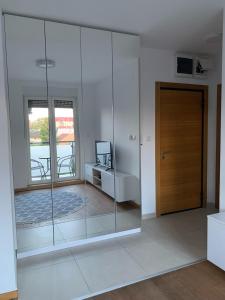 Zimmer mit Glaswänden und Holztür in der Unterkunft Mila Apartment sajam in Novi Sad