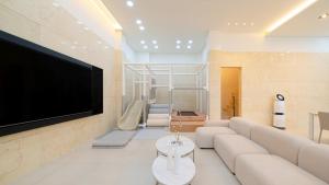 Milos Pool Villa - K102 في يوسو: غرفة معيشة مع أريكة وتلفزيون بشاشة مسطحة