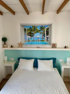 a bedroom with a bed with a window with a view of the beach at La Paloma Blanca in Playa Blanca