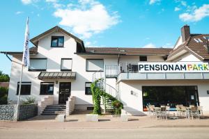 a white building with a sign that reads parsonamnamn park at Pension am Park in Rust