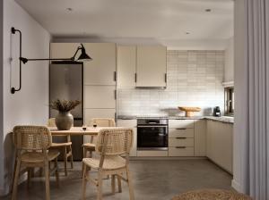 uma cozinha com armários brancos e uma mesa e cadeiras em Azera Suites em Alikanás
