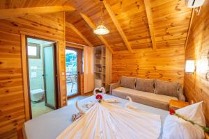 a log cabin bedroom with a bed and a couch at Apartments and bungalow Casa Palma in Ulcinj