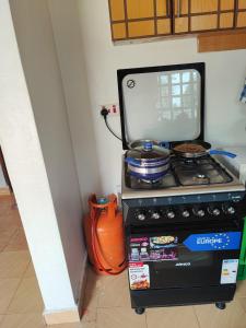 um fogão no canto de uma cozinha em Camp-Flo 3br Guest House-Eldoret em Eldoret