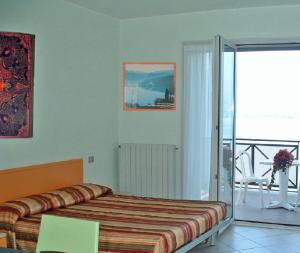 Residence Tre Ponti في فيربانيا: غرفة نوم بسرير وشرفة