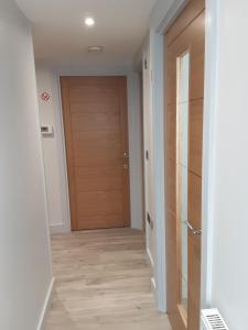 un pasillo con una puerta de madera en una casa en 2 The Maltings Apartments, en Shepton Mallet
