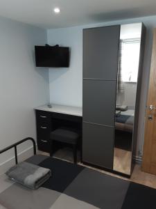 1 dormitorio con escritorio, espejo y cama en 2 The Maltings Apartments, en Shepton Mallet