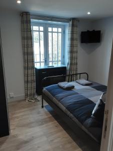 1 dormitorio con cama, lavabo y ventana en 2 The Maltings Apartments, en Shepton Mallet