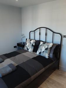 1 cama con almohadas blancas y negras en un dormitorio en 2 The Maltings Apartments, en Shepton Mallet