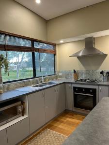 a kitchen with white cabinets and a sink and a window at Thie My Chree Retreat in Herne Hill