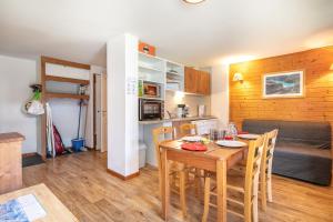 a dining room and kitchen with a table and a couch at Le Silène - Appt pour 6 in Chamrousse