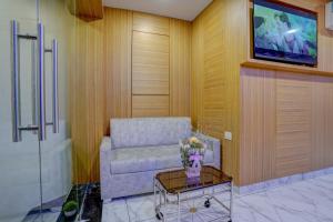 un soggiorno con un divano e una TV di Hotel Arts International a Mumbai