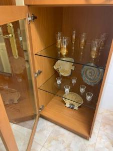 un armario de cristal con vasos y cuencos. en Piso de la pala, en Pontevedra