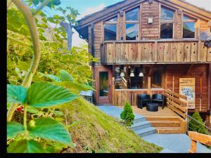 uma grande casa de madeira com um alpendre e escadas em Stirling Luxury Chalet & Spa em Saas-Fee