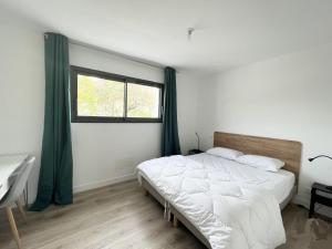 um quarto com uma cama grande e uma janela em Le Clos Guiton em La Rochelle