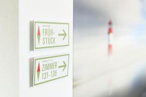 a white door with three signs on it at Hotel NordRaum in Bremen