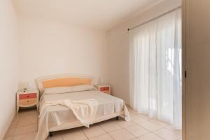 una camera da letto bianca con un letto e una finestra di Elegant Residence Ea Bianca 2 Bedroom sleeps 6 extra bed available n0614 a Cala Bitta