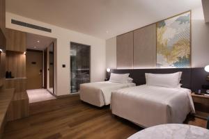 a hotel room with two beds and a hallway at PARKROYAL Langkawi Resort in Pantai Cenang