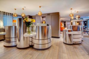 a lobby with stainless steel tables and flowers on them at Design Hotel f6 in Geneva +50 photos