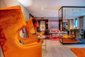 un soggiorno con sedia arancione e divano di Design Hotel f6 a Ginevra